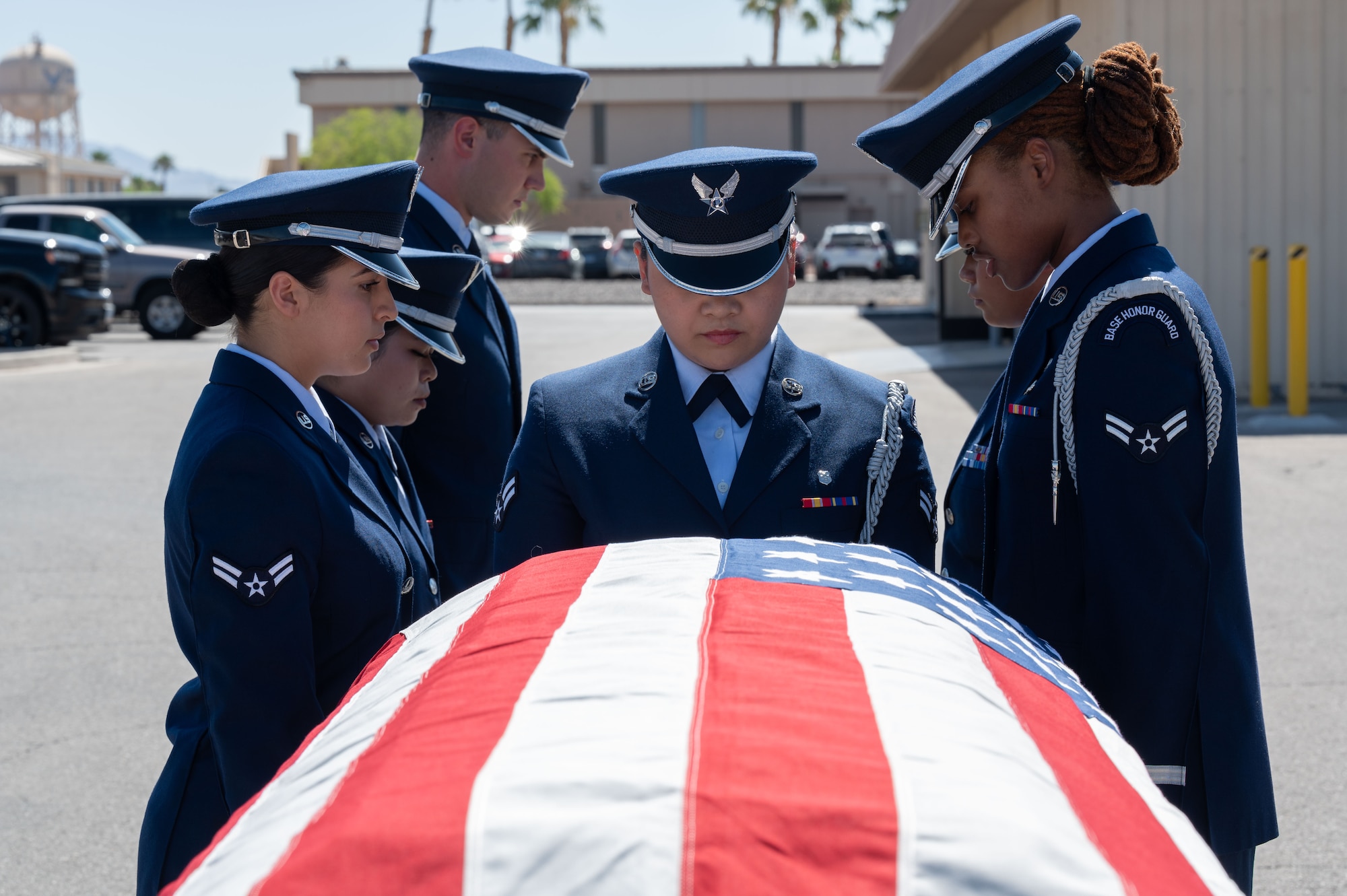 A group of Airmen stand in front of a casket.