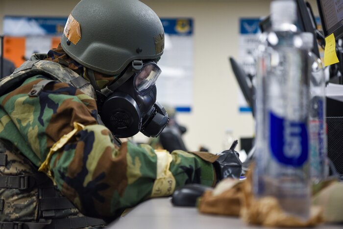 Airman works in Mission Oriented Protective Posture equipment during exercise