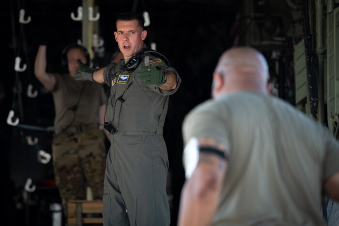 Airman directs the flow of medical "patients" onto a C-130J Super Hercules