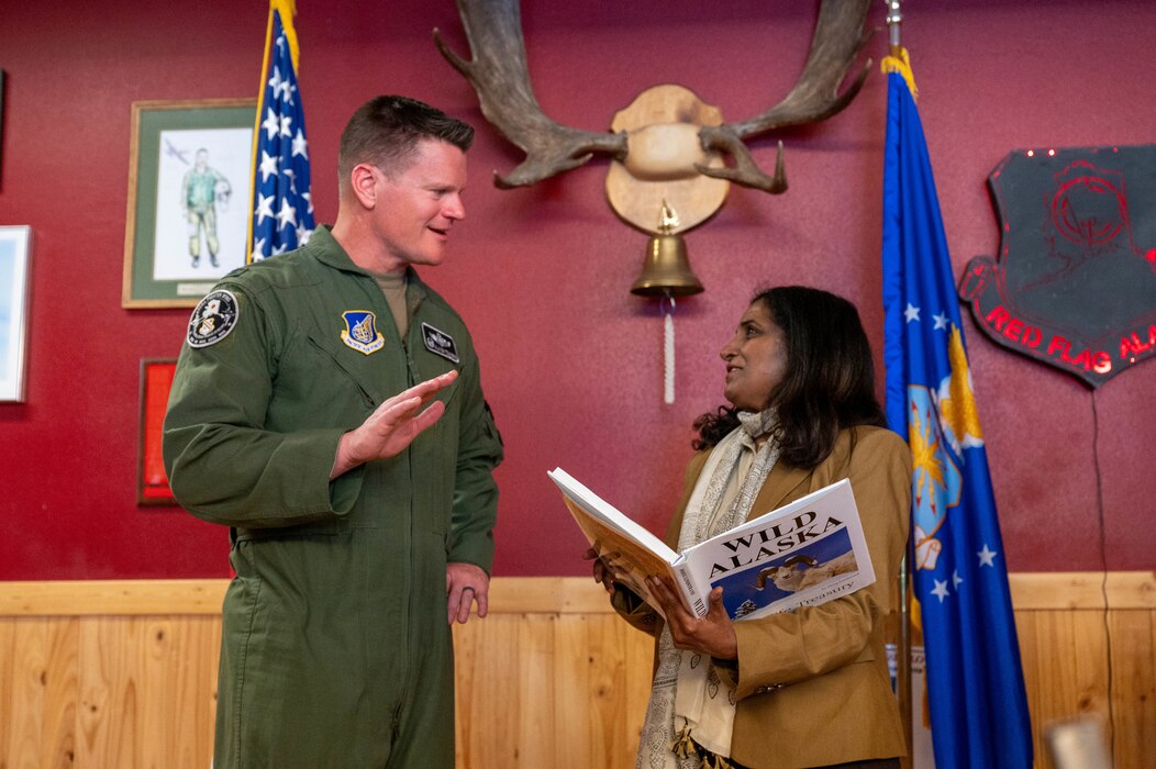 The base commander  talks to the Charge d’Affaires of India to the United States, who holds a book.