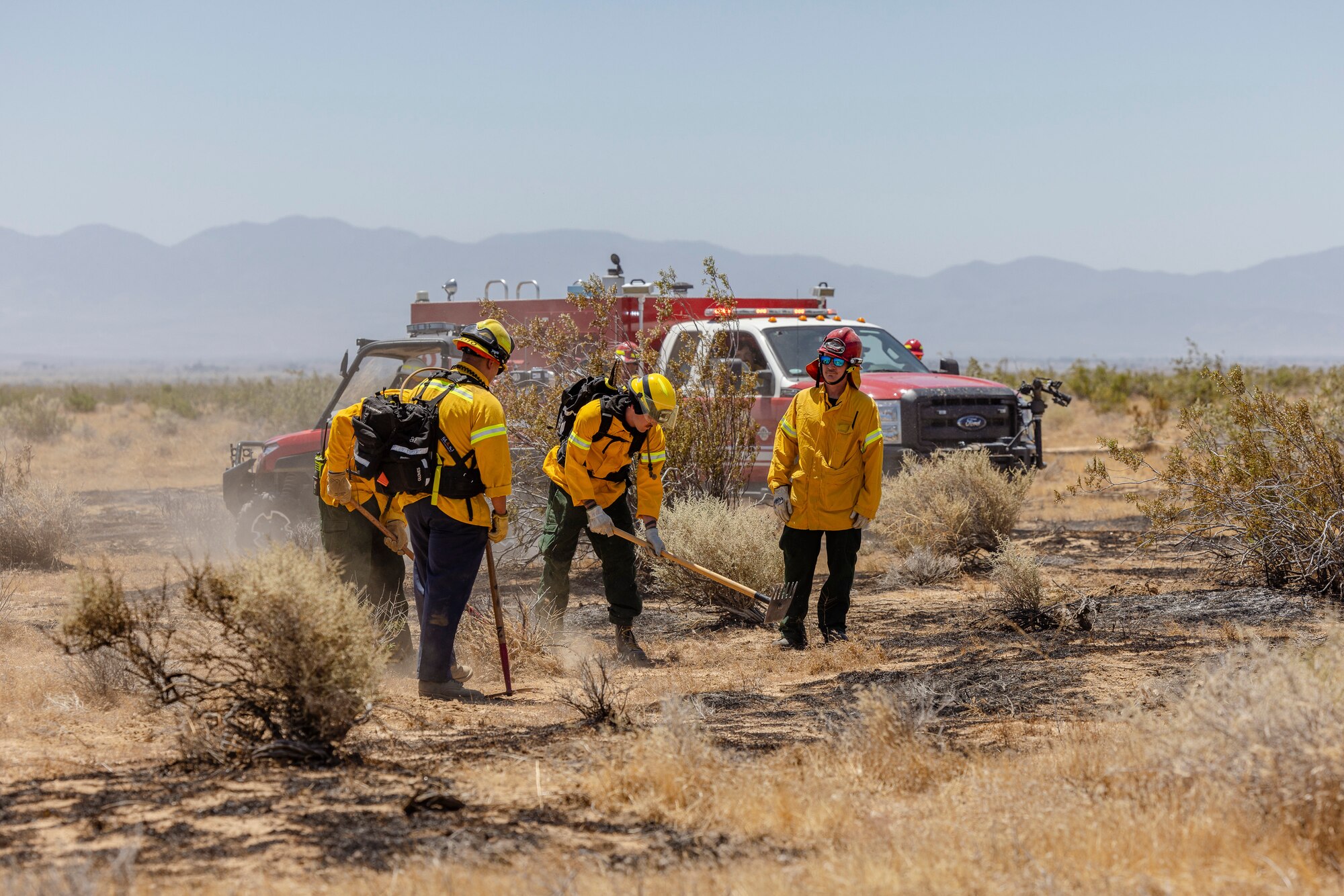 Firefighter crews from the 812th Civil Engineer Squadron Fire and Emergency Services respond to a brush fire near the Combat Arm Training and Maintenance facility on Edwards Air Force Base, California, June 7. The crews' quick reaction prevented the fire to spread to nearby structures and on-base housing. (Air Force photo by Lindsey Iniguez)