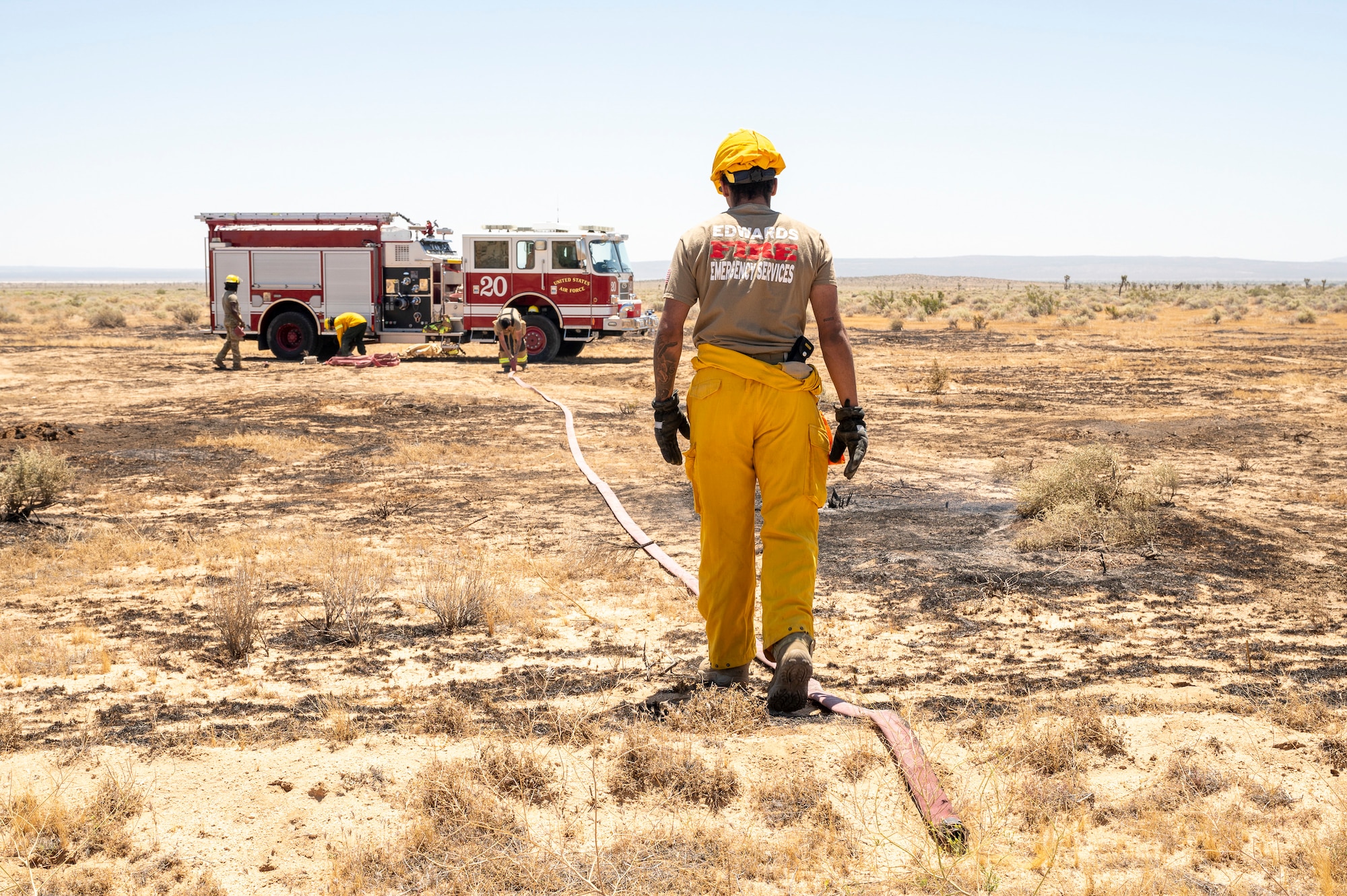Firefighter crews from the 812th Civil Engineer Squadron Fire and Emergency Services respond to a brush fire near the Combat Arm Training and Maintenance facility on Edwards Air Force Base, California, June 7. The crews' quick reaction prevented the fire to spread to nearby structures and on-base housing. (Air Force photo by Laisa Leao)
