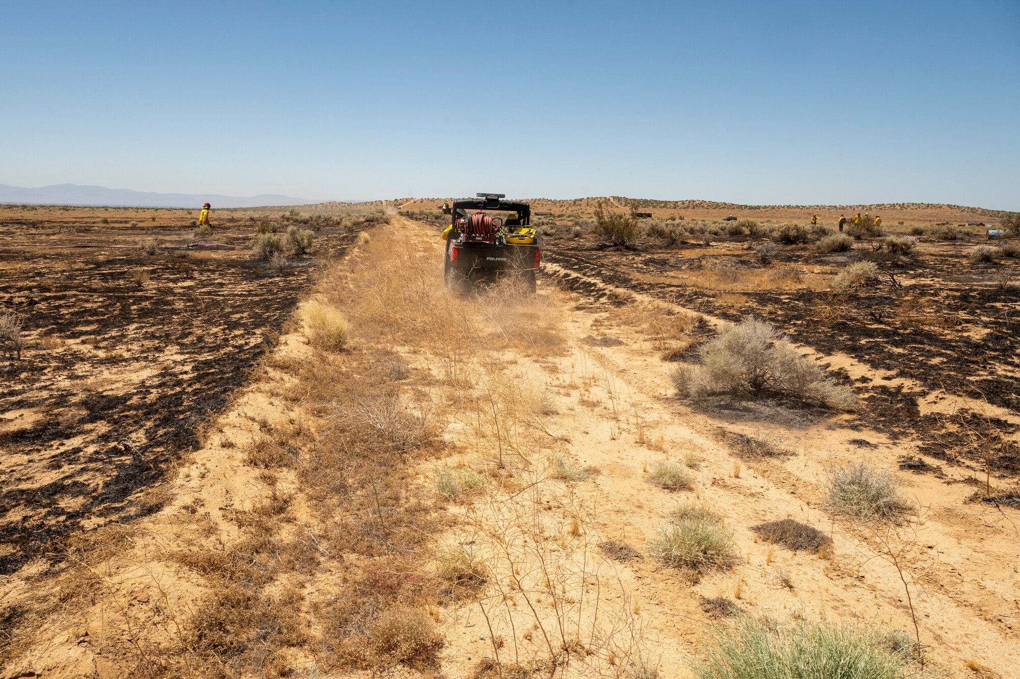 Firefighter crews from the 812th Civil Engineer Squadron Fire and Emergency Services respond to a brush fire near the Combat Arm Training and Maintenance facility on Edwards Air Force Base, California, June 7. The crews' quick reaction prevented the fire to spread to nearby structures and on-base housing. (Air Force photo by Laisa Leao)