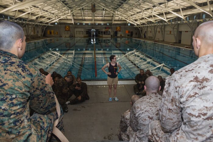 U.S. Marine Corps Staff Sgt. Leeanna Hudson, a Marine Corps Instructor of Water Survival with Support Battalion, Recruit Training Regiment, gives a brief to recruits with Hotel Company, 2nd Recruit Training Battalion, during a water survival class at Marine Corps Recruit Depot San Diego, California, June 4, 2024. Recruits are taught basic water survival prior to conducting their basic swim qualification. Basic swim qualification consists of a 25-meter swim, tower jump into the water, four-minute tread, 25-meter pack swim, and an underwater gear shed. (U.S. Marine Corps photo by Lance Cpl. Janell B. Alvarez)