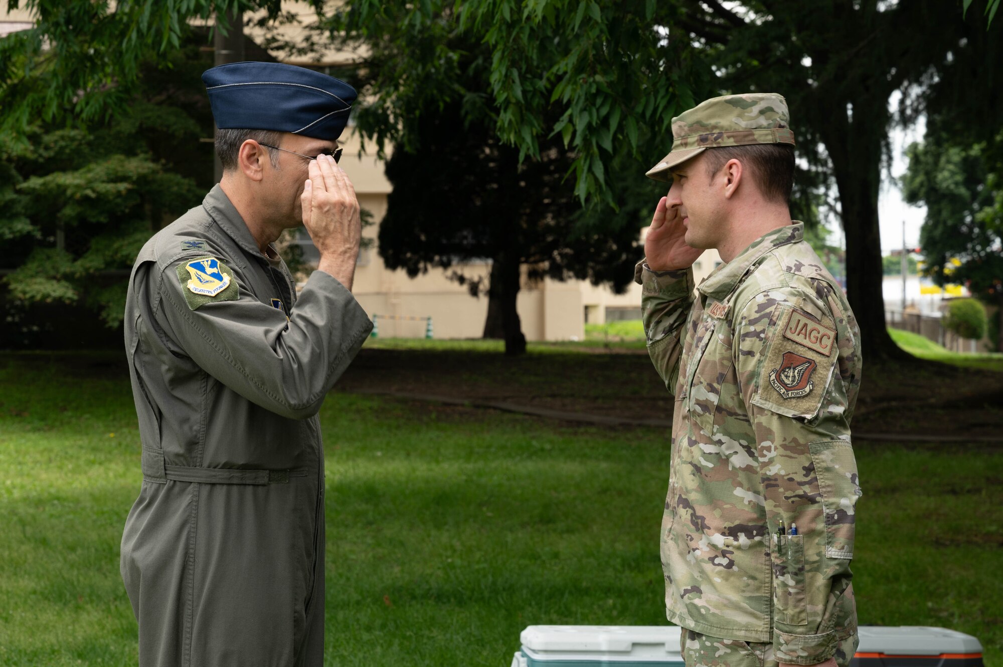 Two servicemen salute eachother.