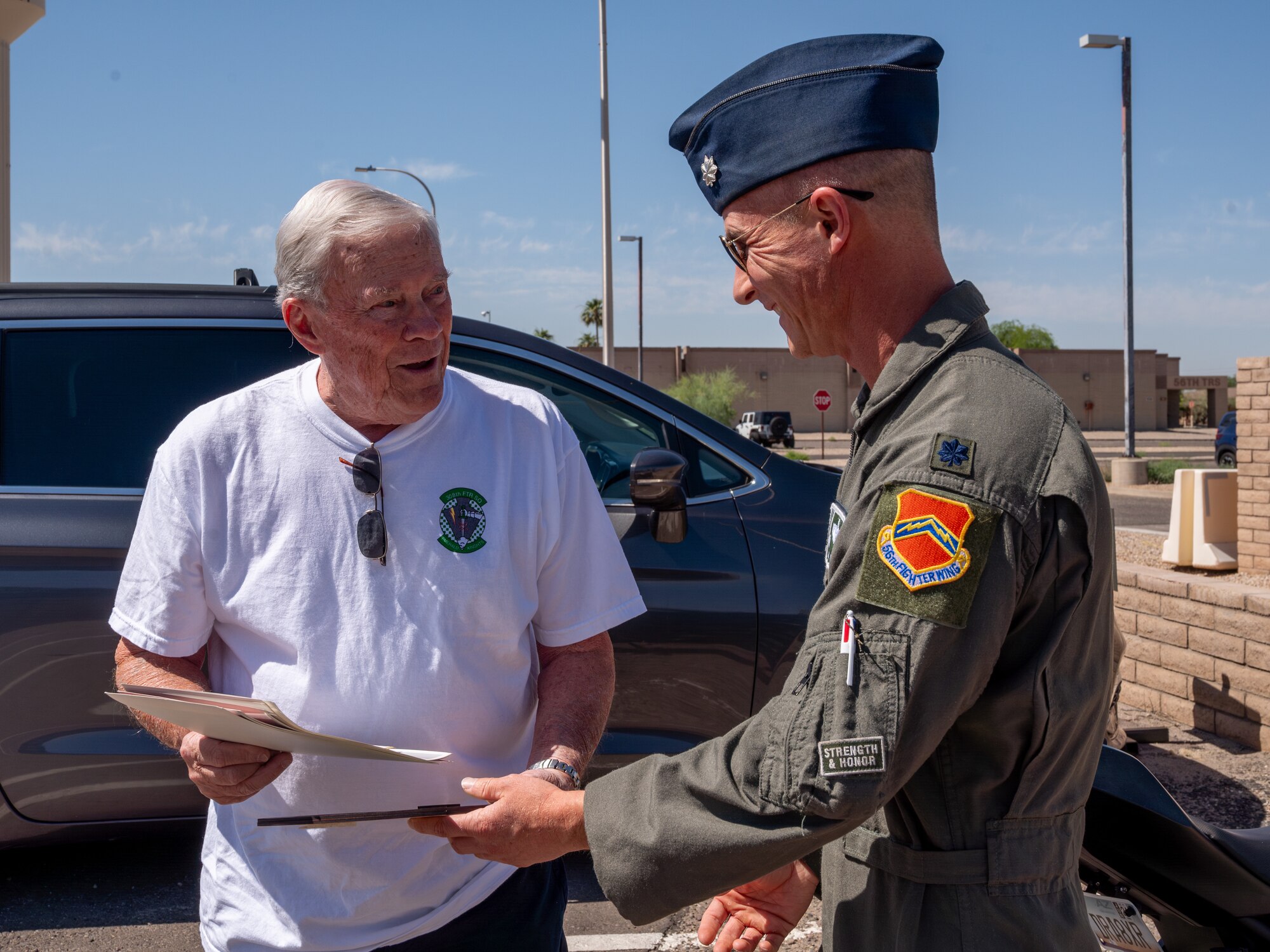 U.S. Air Force Lt. Col. Brett Black (right), 308th Fighter Squadron commander, greets retired Lt. Col. David Kling (left) outside the 308th FS during a heritage tour, March. 31, 2024 at Luke Air Force Base, Arizona.