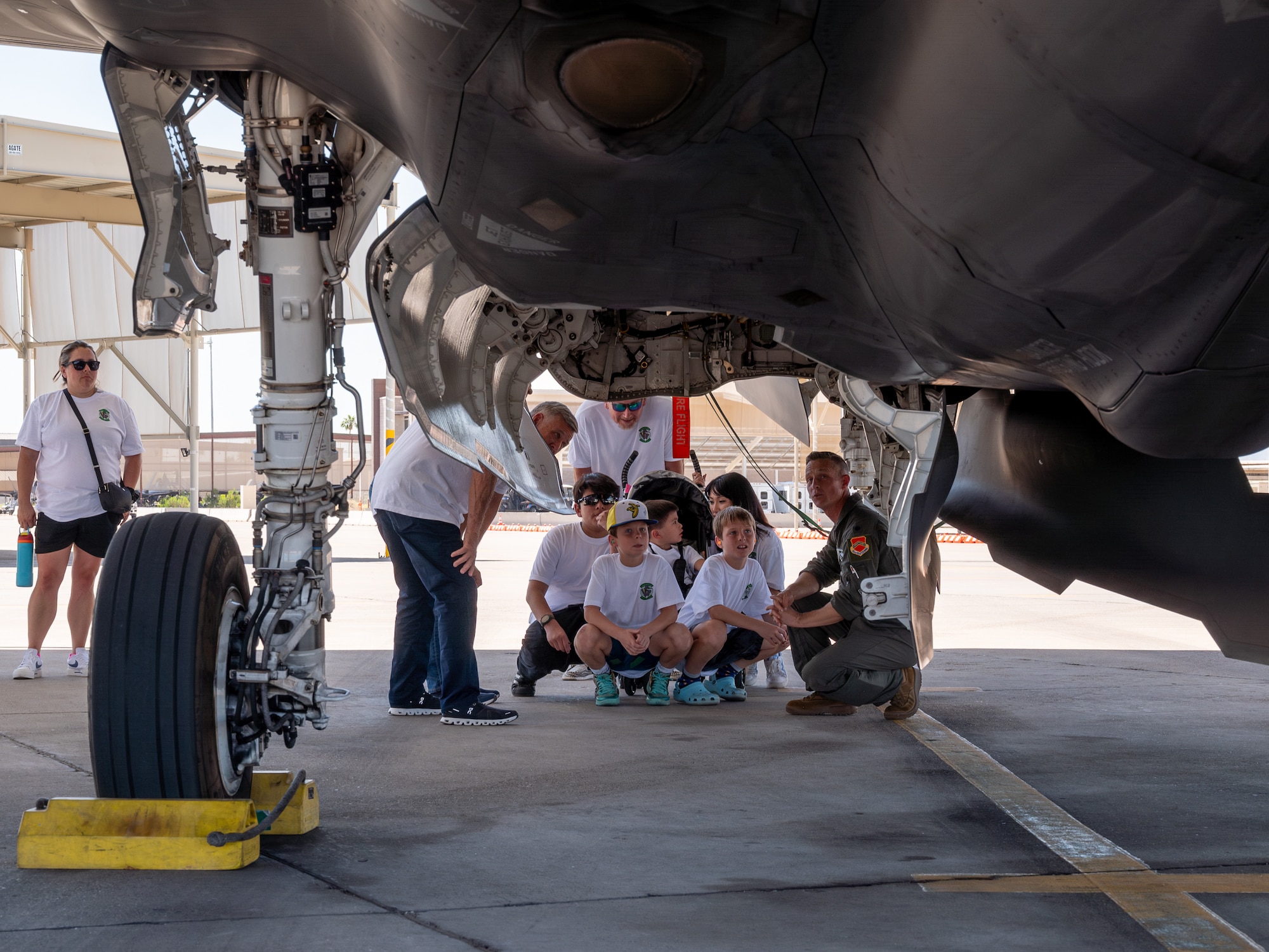U.S. Air Force Lt. Col. Brett Black (right), 308th Fighter Squadron commander, shows an F-35A Lightning II to retired Lt. Col. David Kling (left) and his family, during a heritage tour, March. 31, 2024 at Luke Air Force Base, Arizona.