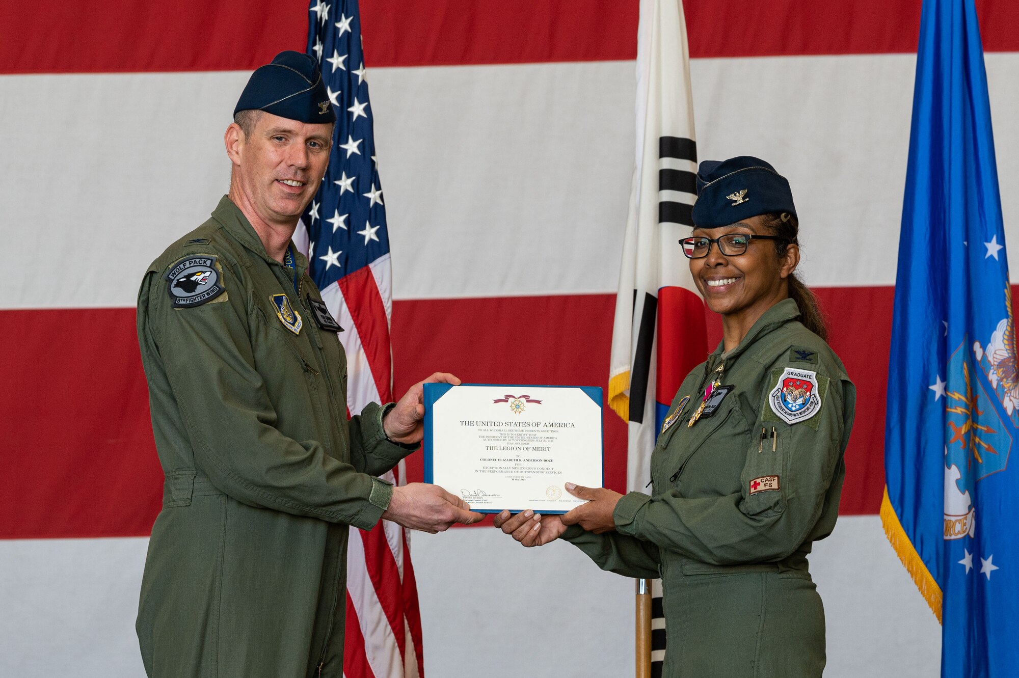 U.S. Air Force Col. Elizabeth Anderson-Doze, 8th Medical Group outgoing commander, receives the Legion of Merit medal from Col. Peter Kasarskis, 8th Fighter Wing commander, during the 8th MDG change of command ceremony.