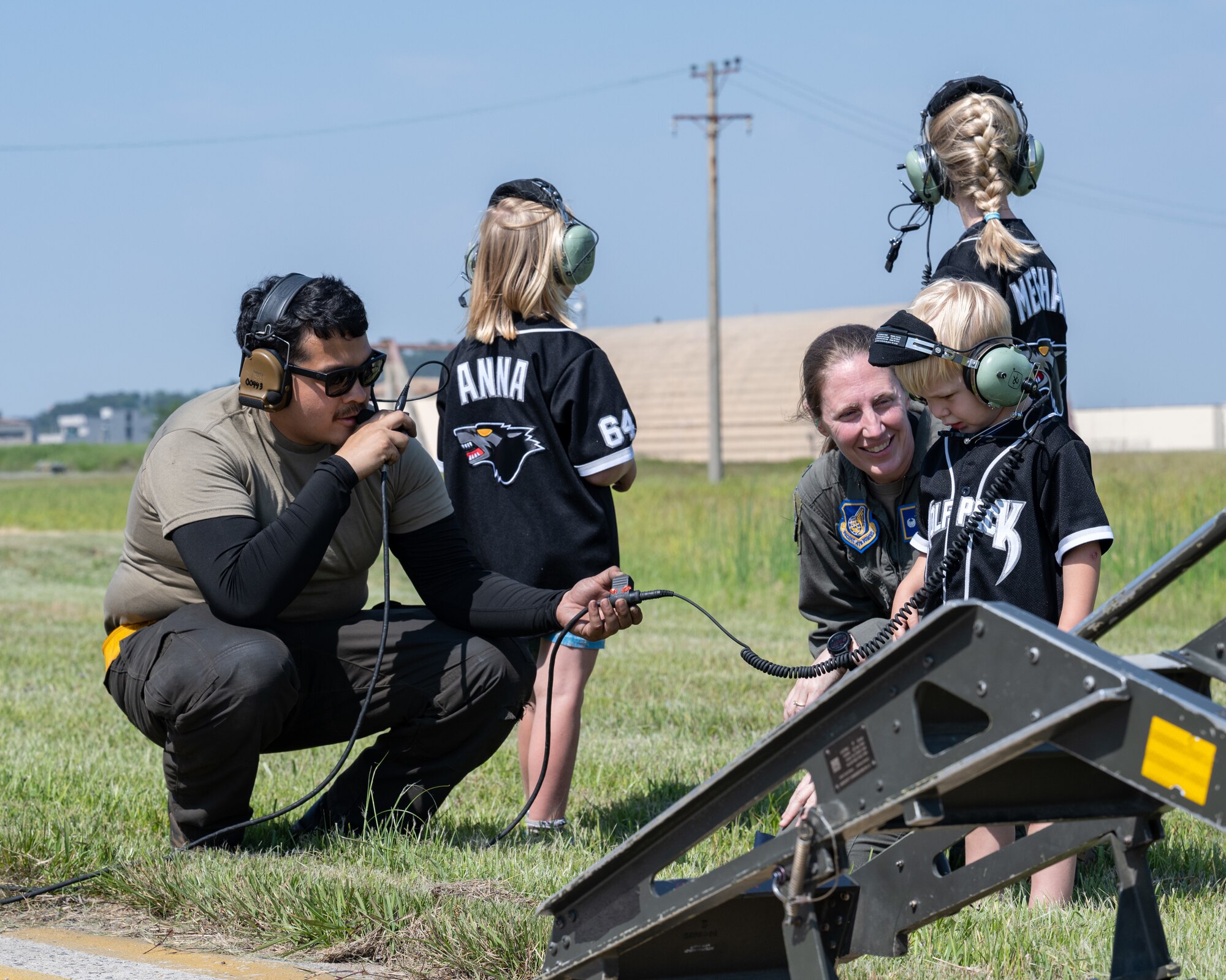 Airman 1st Class Isaac Fonce, 80th Fighter Generation Squadron F-16 crew chief, helps the family of U.S Air Force Col. Matthew Gaetke, 8th Fighter Wing commander, listen in as he prepares for his final flight at Kunsan Air Base, Republic of Korea.