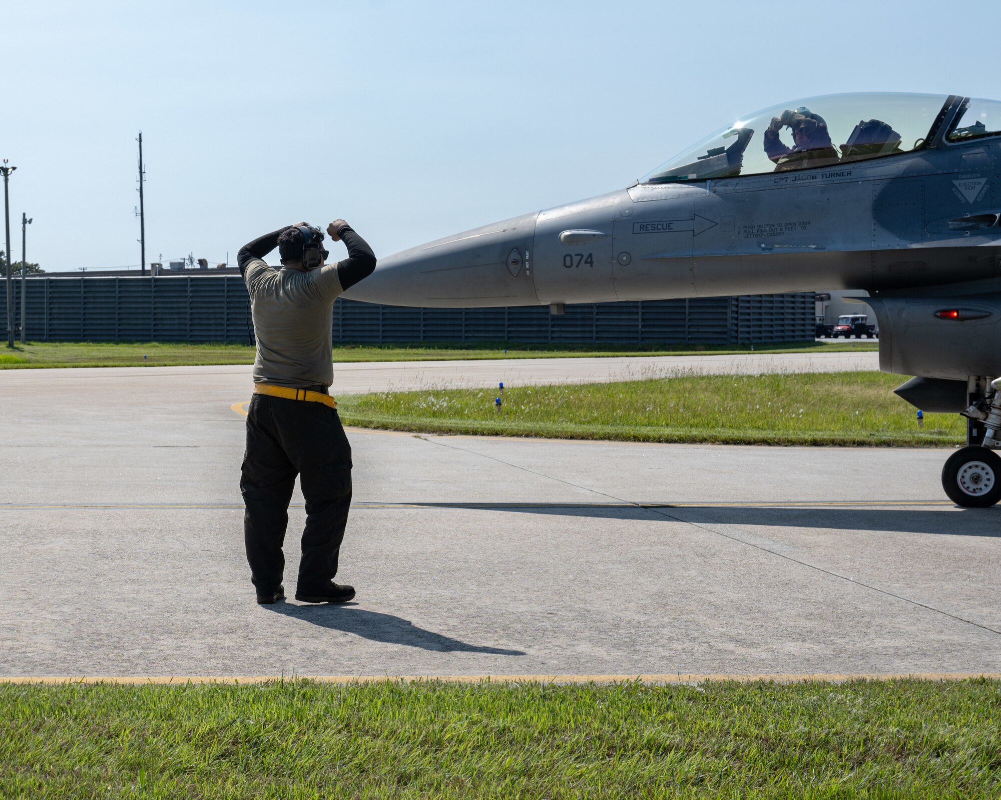 Airman 1st Class Isaac Fonce, left, 80th Fighter Generation Squadron F-16 crew chief, and U.S Air Force Col. Matthew Gaetke, 8th Fighter Wing commander, give each other the ‘crush ‘em’ gesture during Gaetke’s final flight at Kunsan Air Base, Republic of Korea.