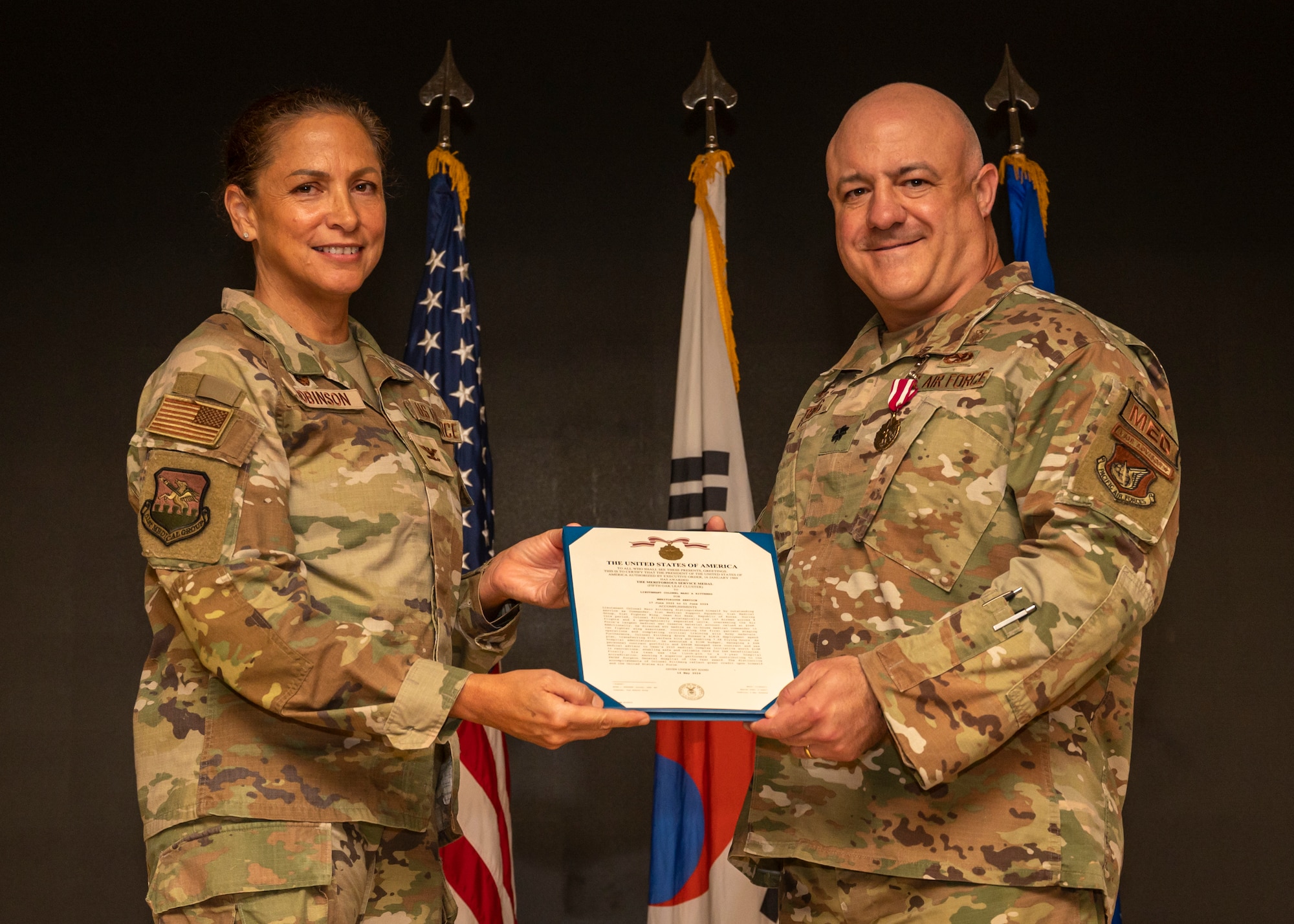 U.S. Air Force Col. Mocha Robinson, left, 51st Medical Group commander, presents the Meritorious Service Medal to Lt. Col. Marc Rittberg, outgoing 51st Medical Support Squadron commander, during a change of command ceremony at Osan Air Base, Republic of Korea, June 11, 2024. The MSM is awarded to members of the armed forces who distinguishes themselves by outstanding achievement or meritorious service. (U.S Air Force photo by Senior Airman Sabrina Fuller-Judd)