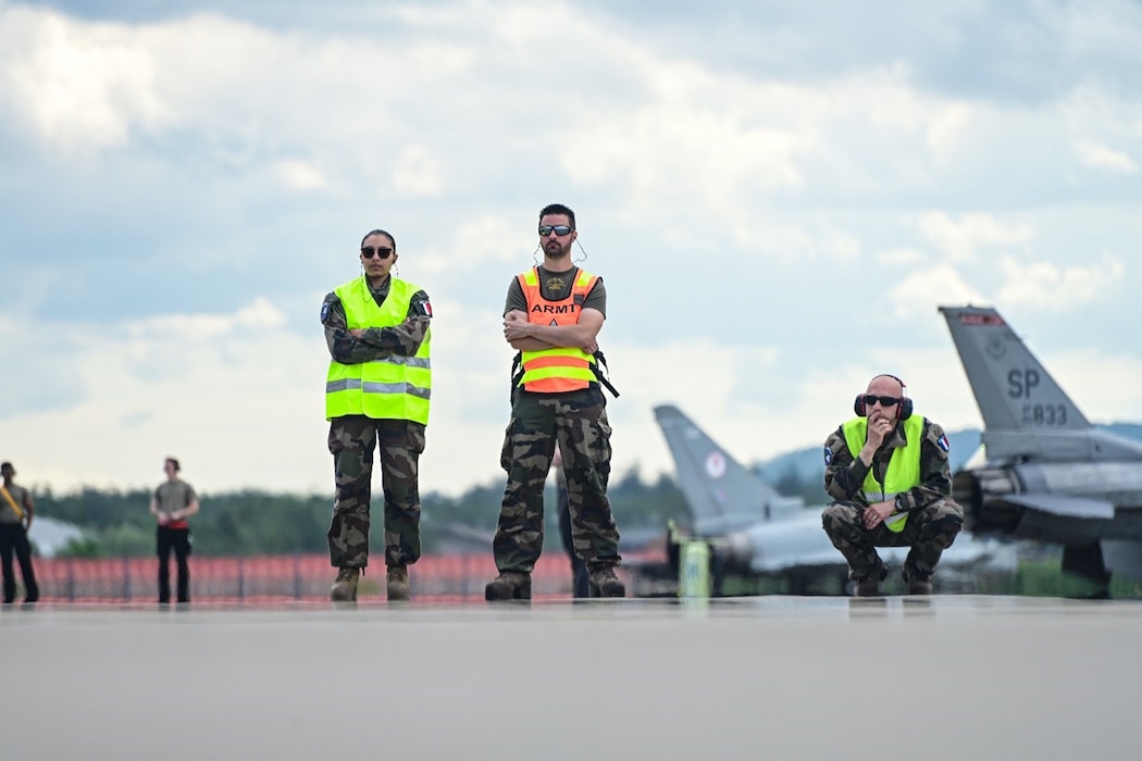 Representatives from the French Air Force stand by during Ramstein 1-v-1, a basic fighter maneuver exercise, June 6, 2024, on Ramstein Air Base, Germany. Maintainers of different NATO countries were given the opportunity during the exercise to cross services and learn more about each other’s airframes, guaranteeing a seamless working relationship in a multi-nation environment. (U.S. Air Force photo by Senior Airman Christian Conrad)
