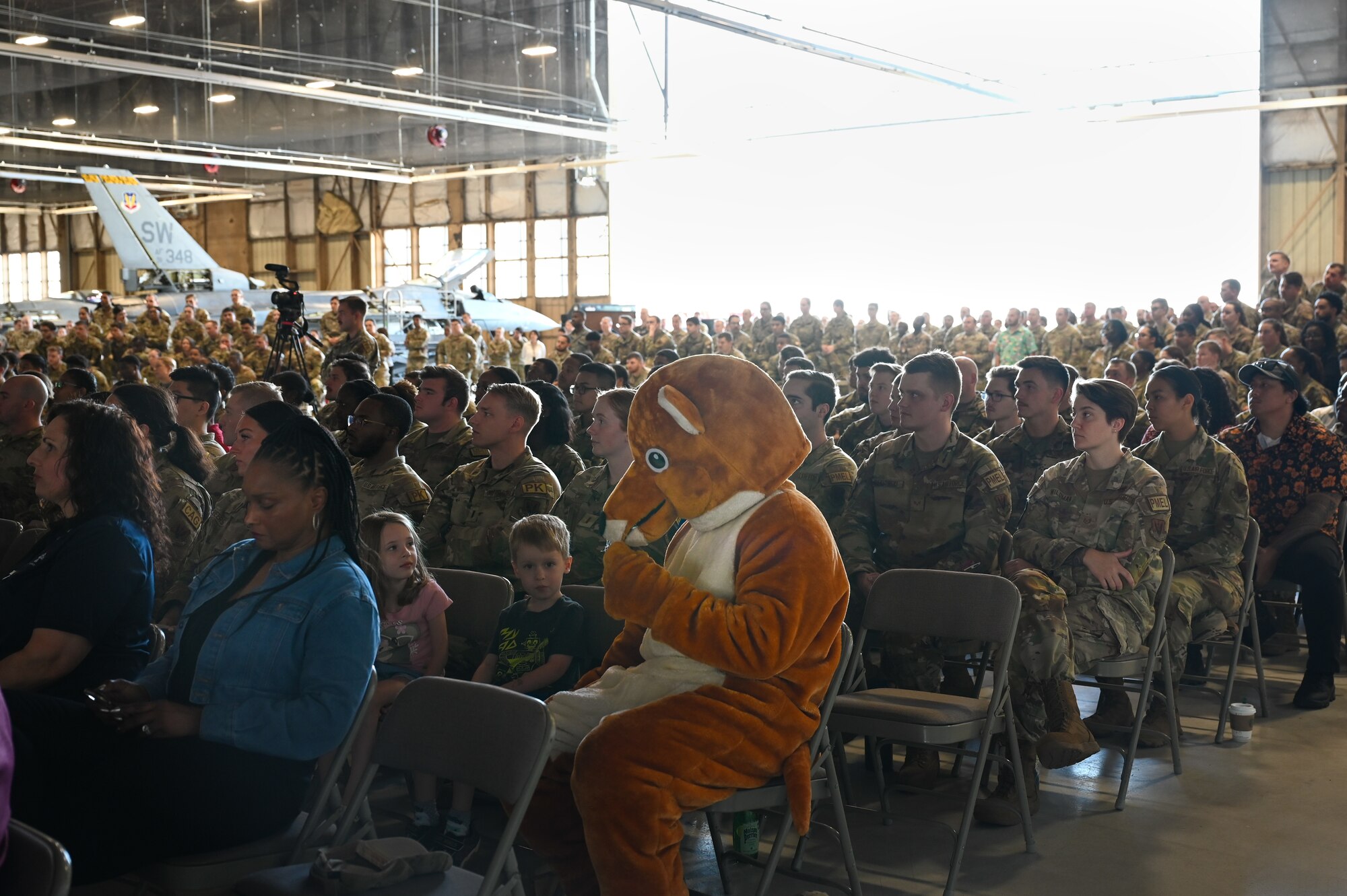 Military members sit down and listens to a speech.