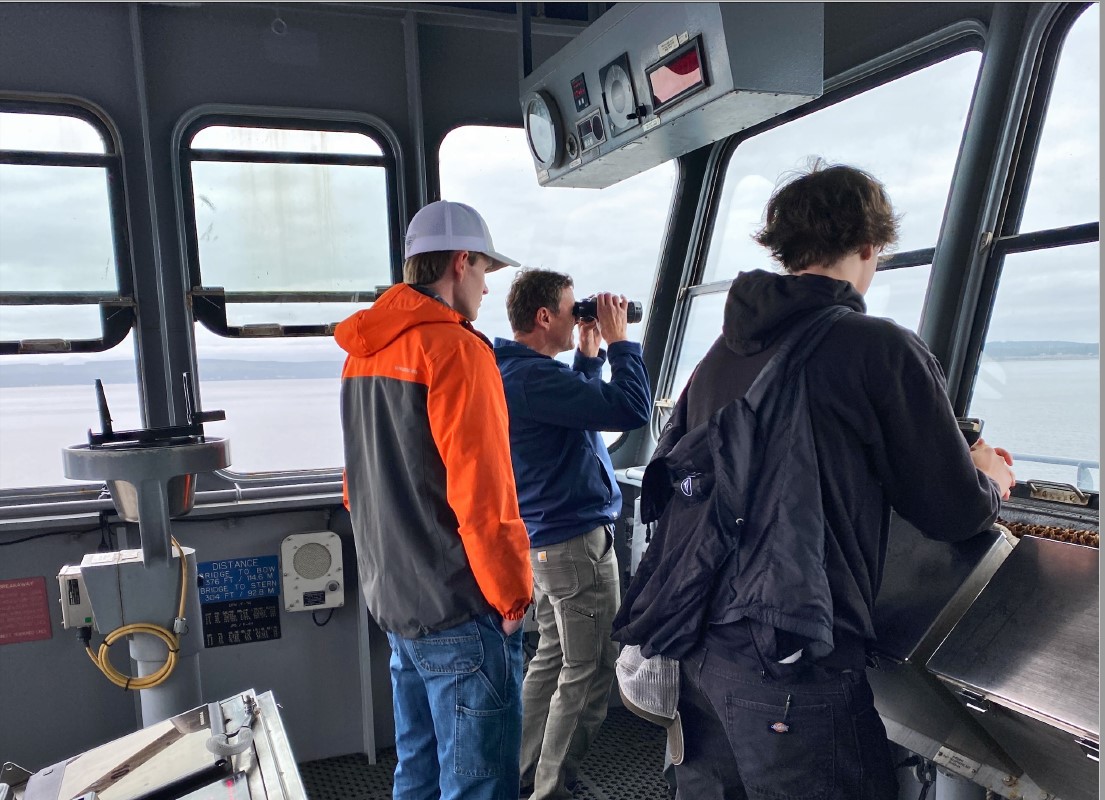 Students from The Seattle Maritime Academy observe operations from the bridge of  the Military Sealift Command dry cargo/ammunition ship USNS Richard E. Byrd (T-AKE 4) during a family cruise (Tiger Cruise) in the Pacific Northwest.