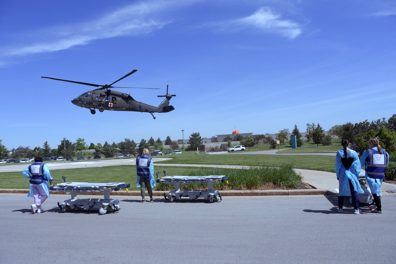 Medical staff from Aurora Medical Center-Summit’s emergency and trauma center wait for a Wisconsin Army National Guard Black Hawk helicopter to arrive so they can move notional patients to the emergency room during a mass casualty exercise May 31, 2024. The scenario called for a single Black Hawk crew to medically evacuate three victims critically injured by a building collapse.