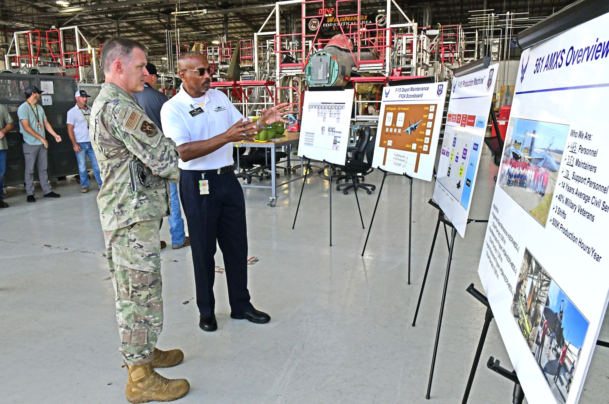Two men standing and talking while looking at various poster boards.