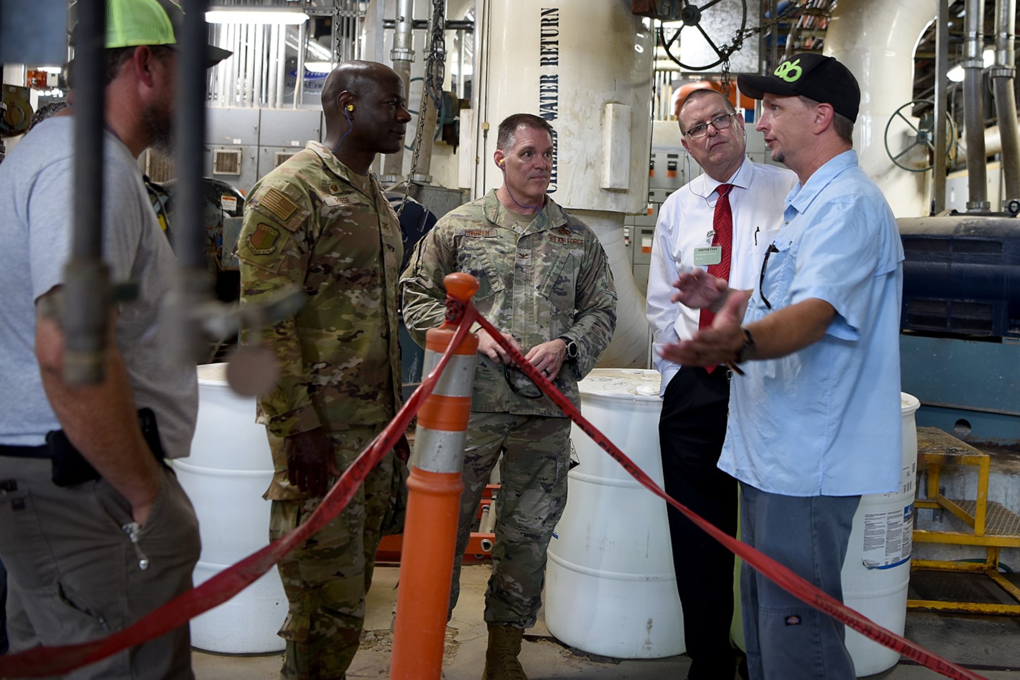 A group of men are standing and speaking to each other.