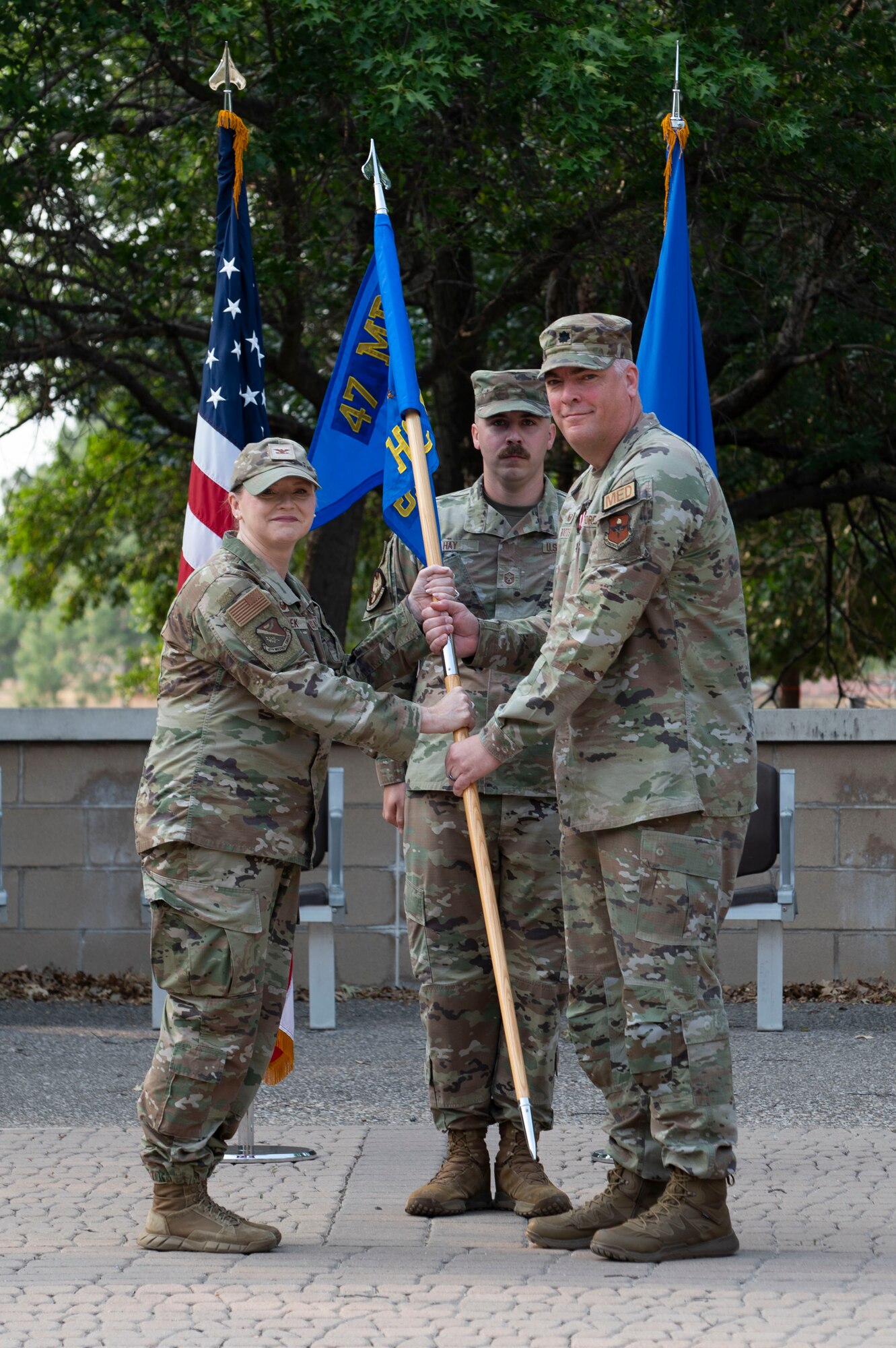 U.S. Air Force Lt. Col. Neil Boots (right), former 47th Healthcare Operations Squadron (HCOS) commander, turns over the 47th HCOS guidon to Col. Angela Lacek (left), 47th Medical Group commander, during the 47th HCOS change of command ceremony at Laughlin Air Force Base, Texas, June 7, 2024. As commander, Boots led 47th HCOS Airmen in providing healthcare services and support in Family Health, Pediatrics, Women’s Health, Laboratory, Radiology, Pharmacy, Immunizations, TRICARE and Patient Administration Services, Resource Management, Information Systems and Logistics. (U.S. Air Force photo by Senior Airman Kailee Reynolds)