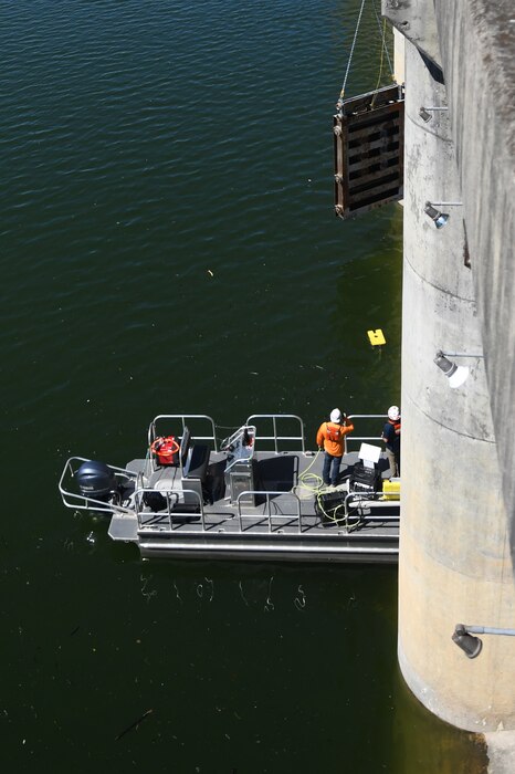 U.S. Army Corps of Engineers dive team members operate an Underwater Remote Operated Vehicle (ROV) to monitor and guide the Center Hill Dam orifice gate reinstallation as it is lowered by crane from the top of the dam in Lancaster, Tennessee, June 10, 2024. The reinstallation of the gate establishes a new summer/fall minimum flow regime aimed at enhancing the habitat of the renowned cold-water trout fishery situated below the dam on Caney Fork River. (USACE Photo by Mike Davis)