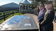 Ryan Hall, Special Agent In Charge of the Army CID Europe Field Office, and Maj. Jason Jordan, executive officer of the Army CID Europe Field Office, read a historic plaque at the Normandy American Cemetery, Colleville-sur-Mer, France, on June 6, 2024.  (U.S. Army photo by Thomas B. Hamilton III)