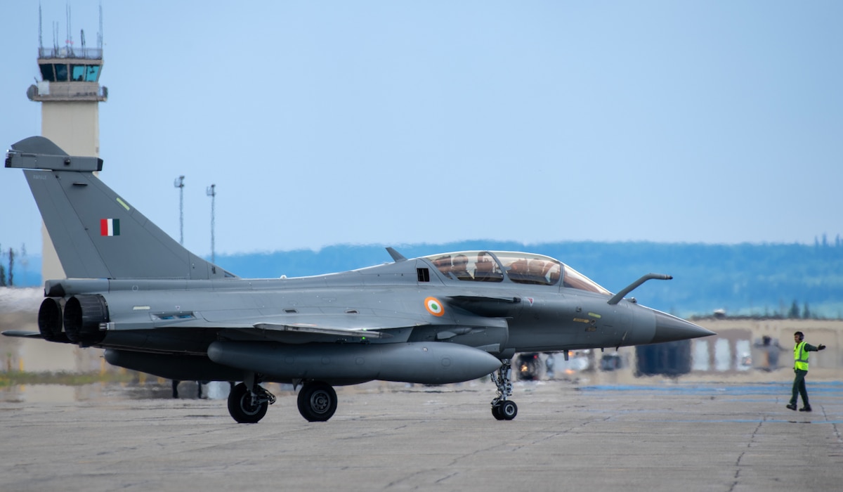 An Indian Air Force maintainer marshals a Rafale aircraft out for take-off.