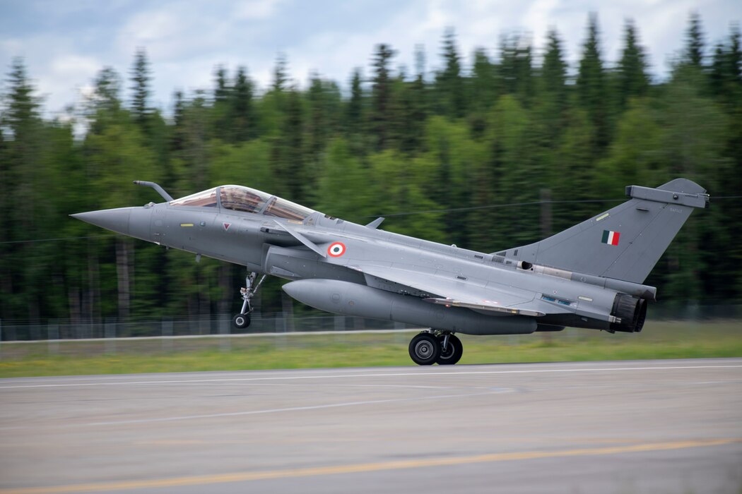 A rafale aircraft takes off with its front tire lifted off the ground.