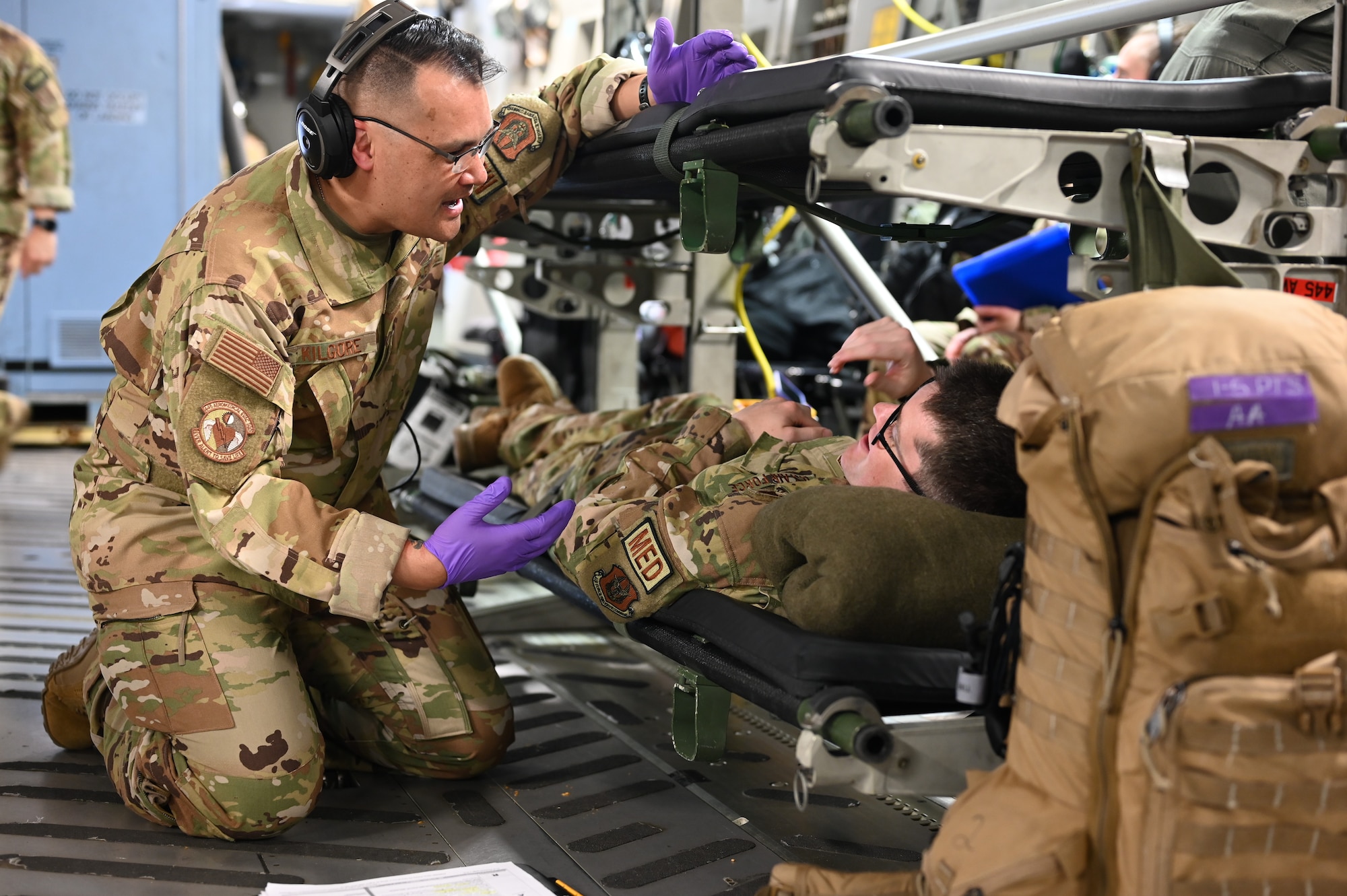 Master Sgt. Charles Kilgore, 445th Aeromedical Evacuation Squadron AE flight chief of operations, checks on a "patient" during a training flight May 9, 2024. Twelve Citizen Reserve Airmen with the 445th Airlift Wing and 12 members with the 349th AES at Travis AFB, California, trained on a C-17 Globemaster III in several locations during their annual training May 8-13, 2024.