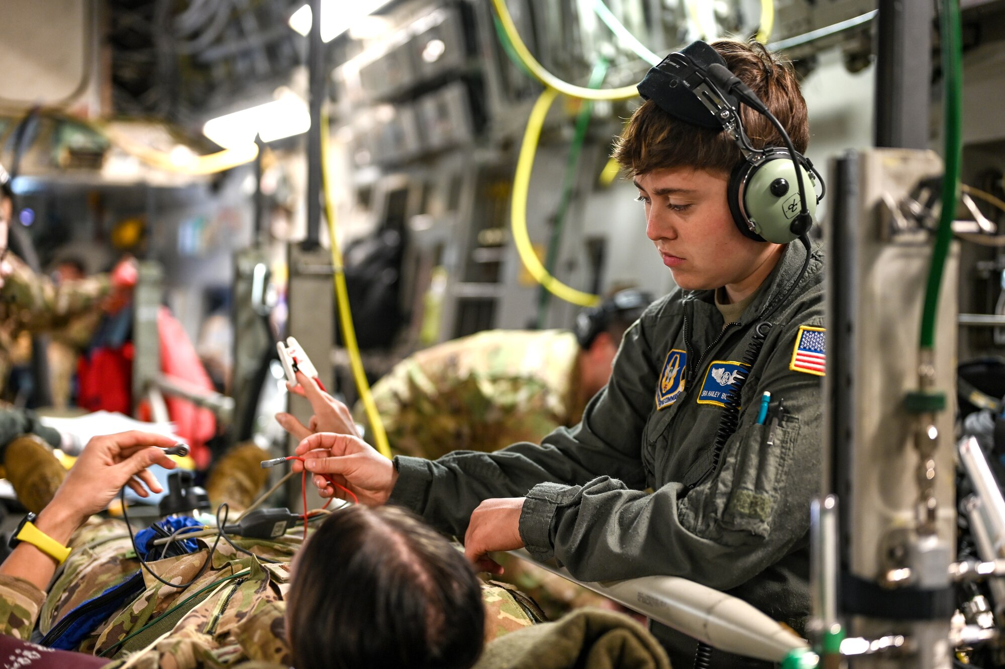 Senior Airman Hailey Bullock, a 445th Aeromedical Evacuation Squadron medical technician, hooks up equipment to monitor the vitals of a “patient” during an AES training flight May 11, 2024. Twelve Citizen Reserve Airmen with the 445th Airlift Wing and 12 members with the 349th AES at Travis AFB, California, trained on a C-17 Globemaster III in several locations during their annual training May 8-13, 2024.