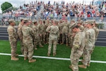 Soldiers with Company A, 1st Battalion, 178th Infantry Regiment, Illinois Army National Guard, huddle around Sgt. 1st Class Paul Minder, platoon sergeant, Company A, before a mobilization ceremony in Peoria, Illinois, June 4, 2024. The battalion’s mission while forward deployed to six different countries within Southwest Asia will be to secure and protect U.S. and allied forces, as well as to train with allies in the region.