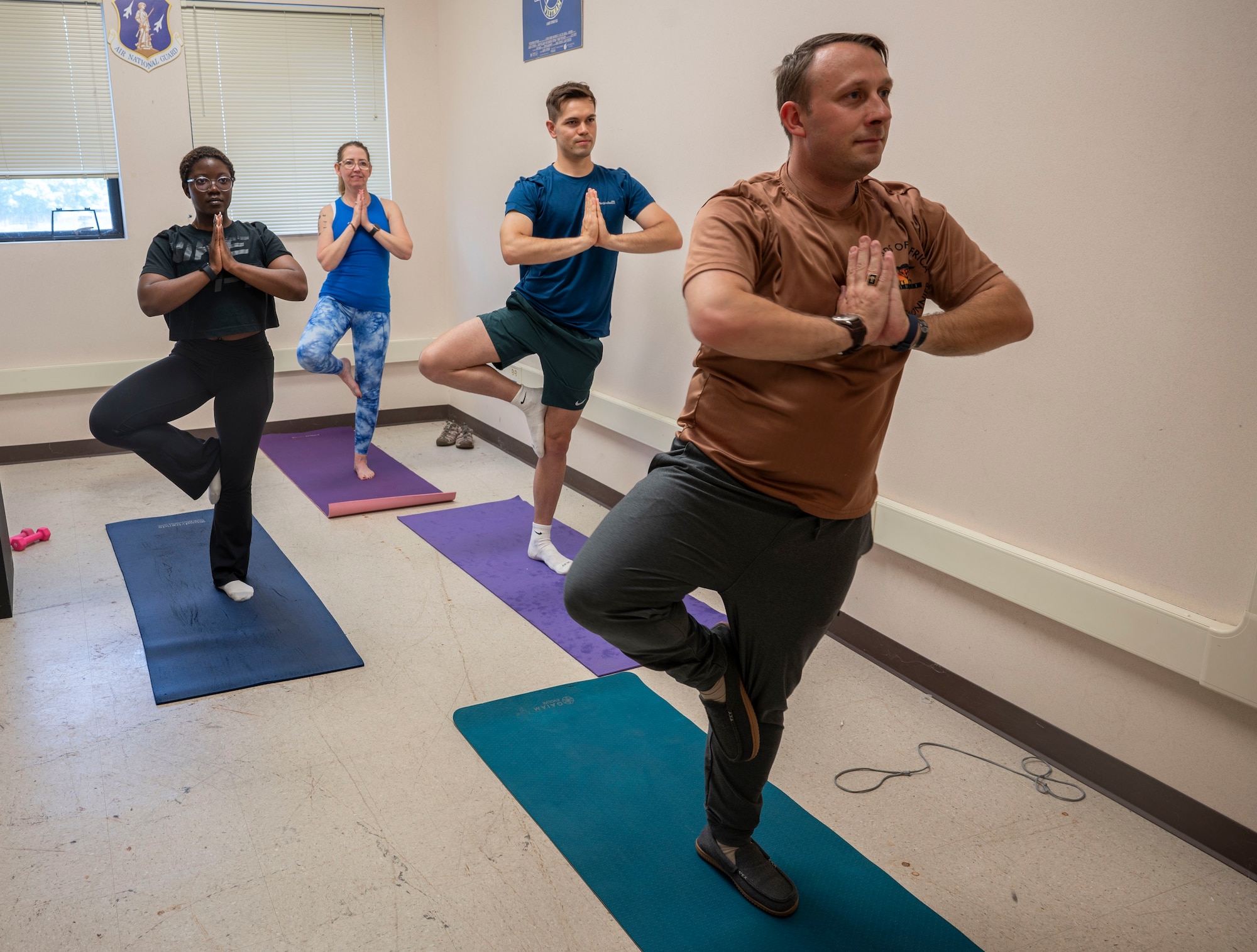 Members of the 174th Attack Wing practice yoga at Hancock Field Air National Guard Base in Syracuse, NY, Jun. 9. The yoga sessions align with the National Guard's Holistic Wellness Challenge. (U.S. Air National Guard photo by Staff Sergeant Duane Morgan)