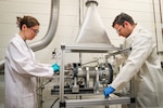 Naval Surface Warfare Center Indian Head Division’s Novel Metal Fuel and Synthesis Combustion Team of Emma Skekel (left) and Dr. Demitrios Stamatis (right) are the recipients of a 2024 Dr. Delores M. Etter Top Scientist and Engineering team award for designing and developing a constant volume combustion (CVC) vessel. The CVC uses only gram amounts of material, saving time and money. This capability has improved metal fuel development and ultimately aims to improve range, speed and lethality of weapons systems. (U.S. Navy photo released)