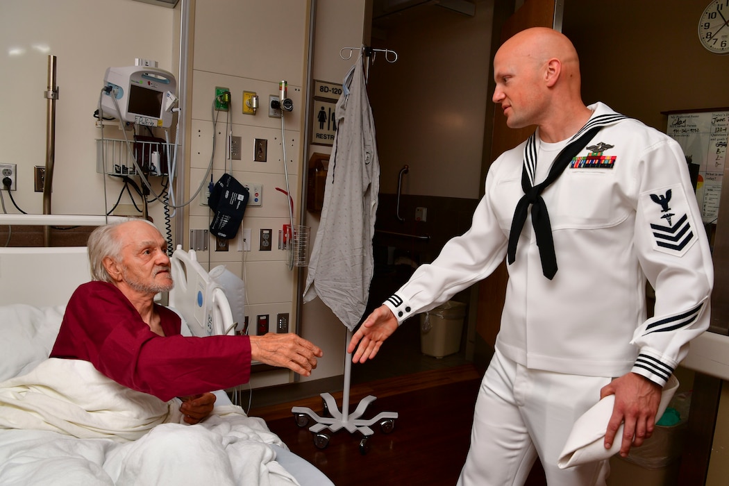 Hospital Corpsman 1st Class Christopher Marchetta, assigned to the Independence-variant littoral combat ship USS Montgomery (LCS 8), greets Army veteran Clayton Allen during a visit to Portland VA Medical Center as part of the annual Portland Fleet Week and Rose Festival in Portland, Oregon June 7, 2024. Portland Fleet Week is a time-honored celebration of the sea services and provides an opportunity for the citizens of Oregon to meet Sailors, Marines and Coast Guardsmen, as well as witness firsthand the latest capabilities of today’s maritime services. (U.S. Navy photo by Mass Communication Specialist 1st Class Heather C. Wamsley)