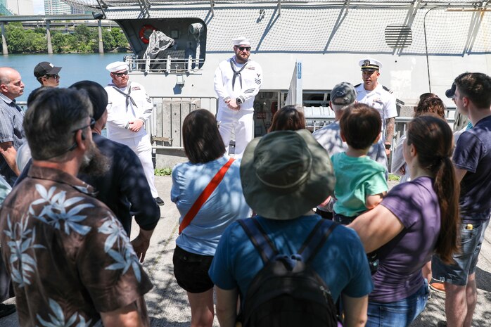 U.S. Navy Sailors stationed aboard the USS Montgomery (LSC-8) brief civilains before a tour of the Mongomery during Portland Fleet Week June 9, 2024. Portland Fleet Week is a time-honored celebration of the sea services and provides an opportunity for the citizens of Oregon to meet Sailors, Marines and Coast Guardsmen, as well as witness firsthand the latest capabilities of today’s maritime services. (U.S. Navy photo by Mass Communication Specialist 3rd Class Justin Ontiveros)