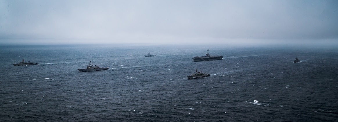 Carrier Strike Group 10 and ships from the Chilean navy transit in formation during a photo exercise while underway in the Pacific Ocean