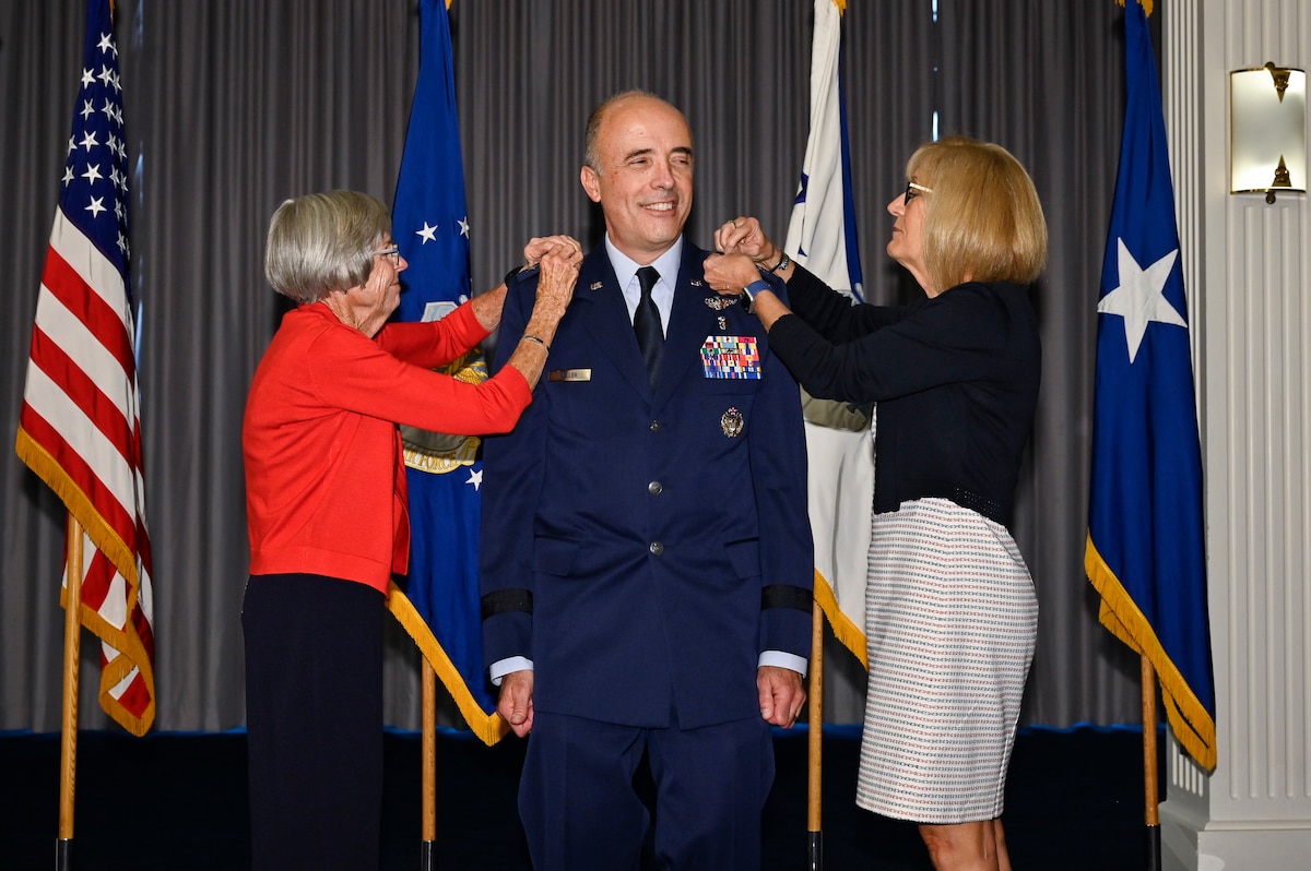 Image of an Airman and civilians posing for a photo.