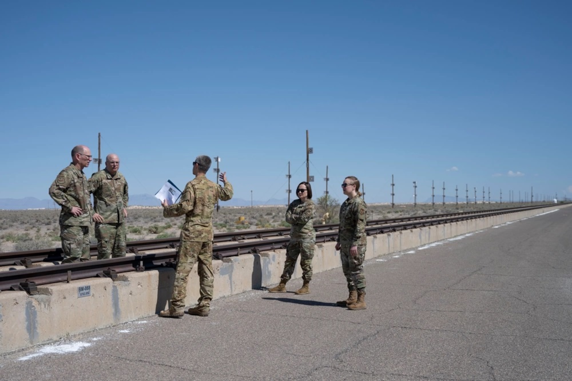 U.S. Air Force Lt. Col. Jared Rupp, 846th Test Squadron commander, center, briefs Air Force Materiel Command leadership about the Holloman High Speed Test Track at Holloman Air Force Base, New Mexico, May 14, 2024. The AFMC command team toured the different squadrons and facilities under the Arnold Engineering Development Complex 704th Test Group to gain a better understanding of the work being done at Holloman. (U.S. Air Force photo by Senior Airman Corinna Sanabia)