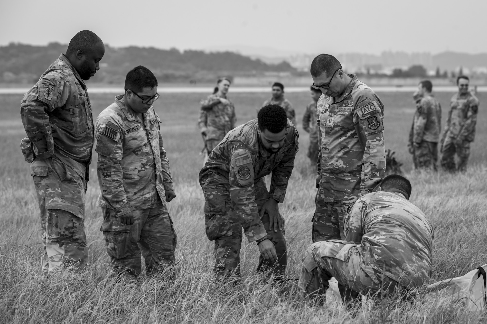 U.S. Air Force Airmen assigned to the 51st Operations Support Squadron and U.S. Soldiers assigned to the 3rd General Support Aviation Battalion, 2nd Combat Aviation Brigade, 2nd Infantry ROK/U.S. Combined Division, establish a helicopter landing zone during a joint training event at Osan Air Base, Republic of Korea, June 5, 2024. The training incorporated agile combat employment concepts and integrated knowledge and skills between U.S. military branches. (U.S. Air Force photo by Senior Airman Sabrina Fuller-Judd) (This image was created in color and converted to black and white)