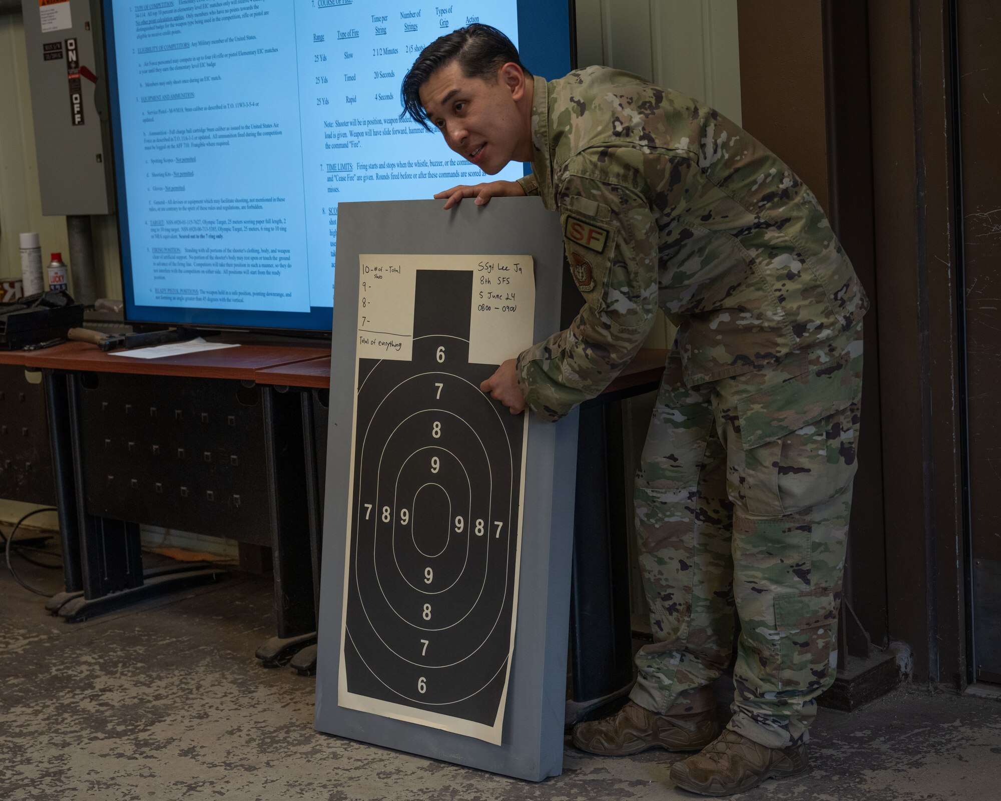 U.S. Air Force Staff Sgt. Jay Lee, 8th Security Forces Squadron combat arms training & maintenance noncommissioned officer in charge, shows how scoring is calculated for the Excellence in Competition pistol match at Kunsan Air Base, Republic of Korea.