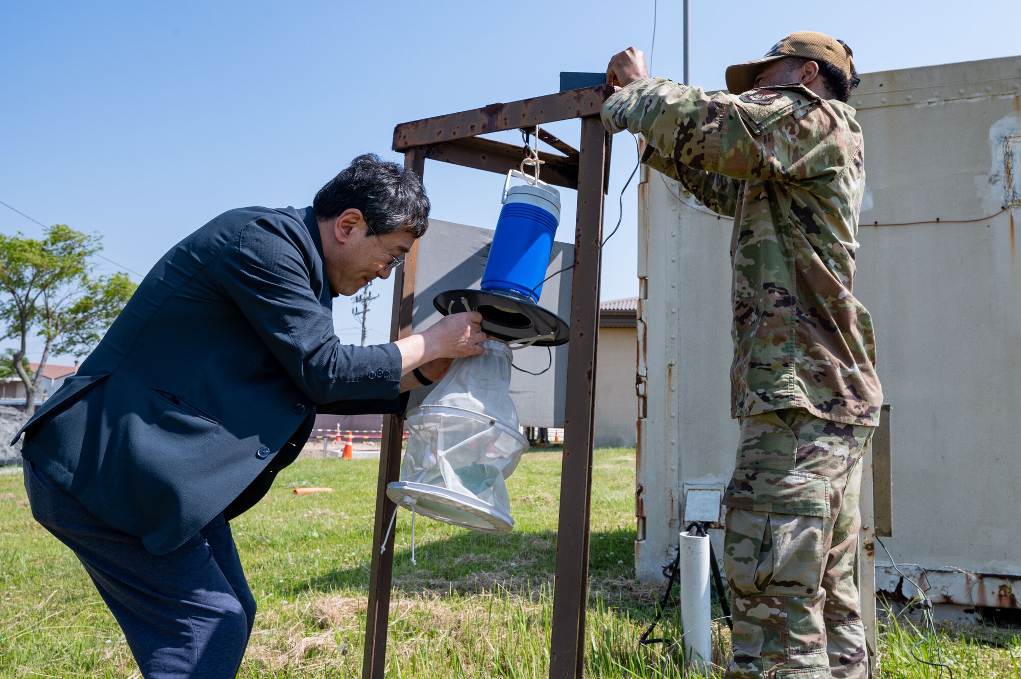 Kye Son Kim, left, 8th Operational Medical Readiness Squadron public health inspector, and  Senior Airman Darius McKay, 8th OMRS entomology program manager, prepare a carbon dioxide light trap during mosquito surveillance season.