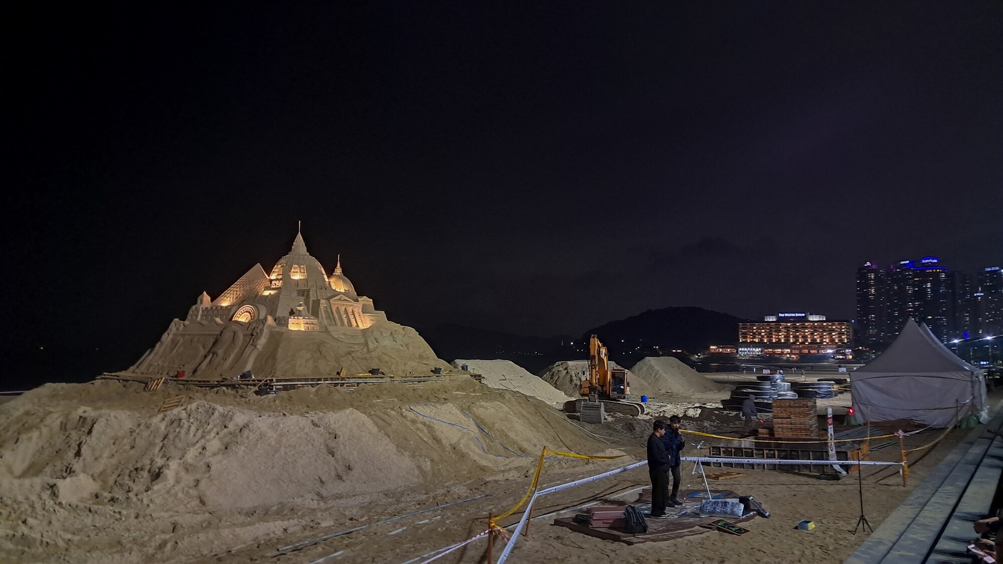 Street performers prepare to sing near sand sculptures on Haeundae Beach in Busan, Republic of Korea, April 30, 2024.