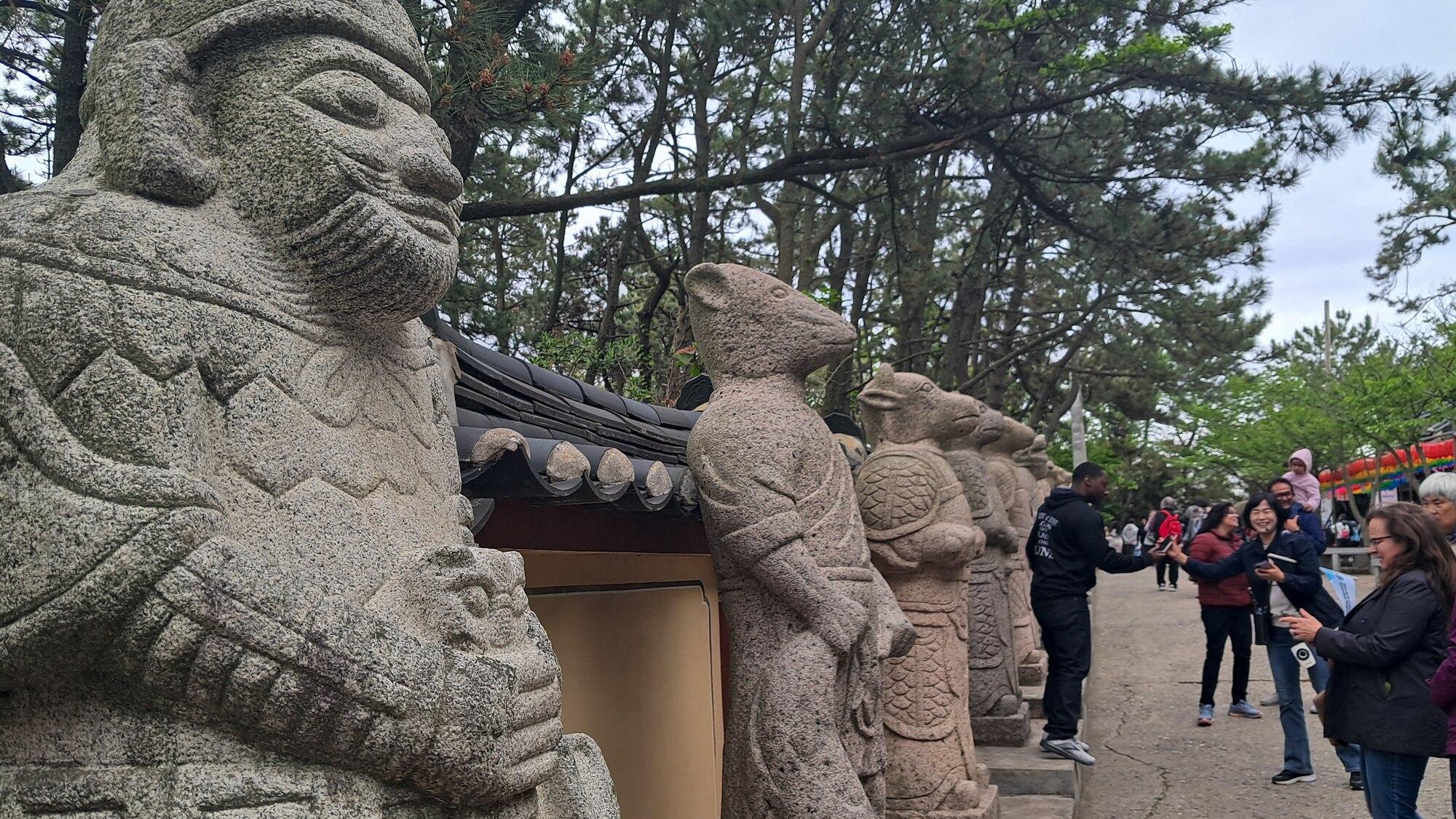Visitors participating in the U.S. Forces Korea Korean Cultural Immersion Program take photos of Korean zodiac animal statues at Haedong Yonggungsa Temple, Republic of Korea, May 1, 2024.