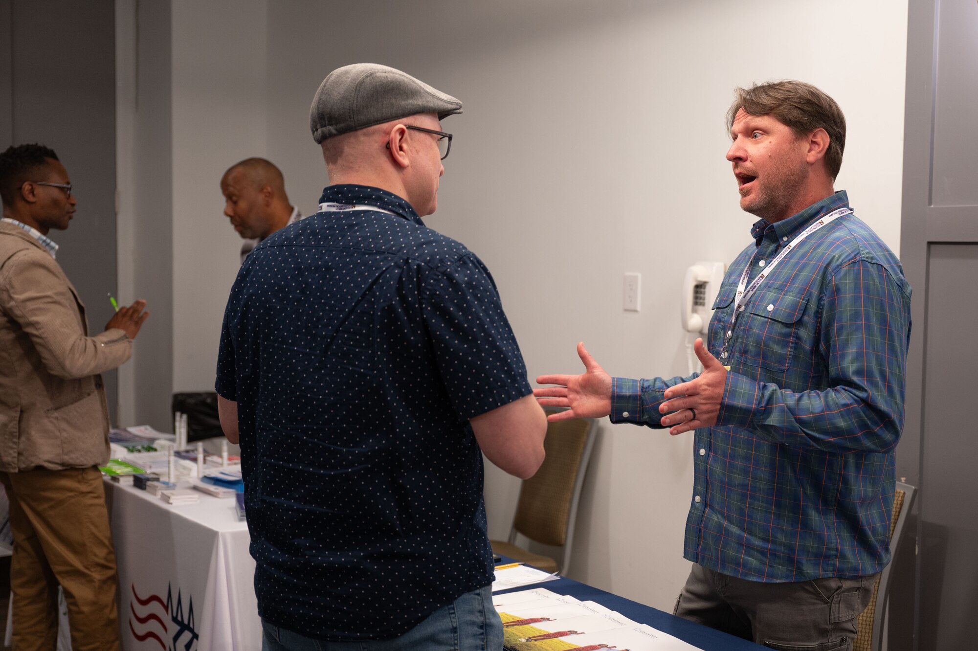A photo of two men in civilian clothes speaking about benefits and services available during the event.