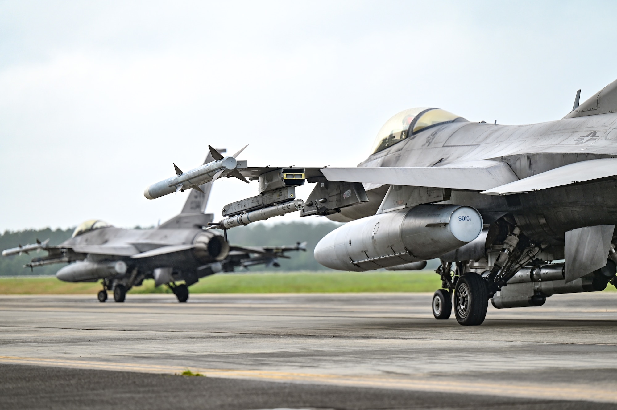 Two jets taxi across the flightline.