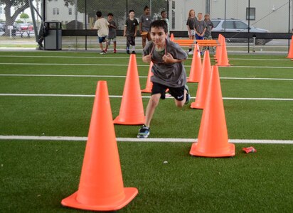 Boy running through orange cones