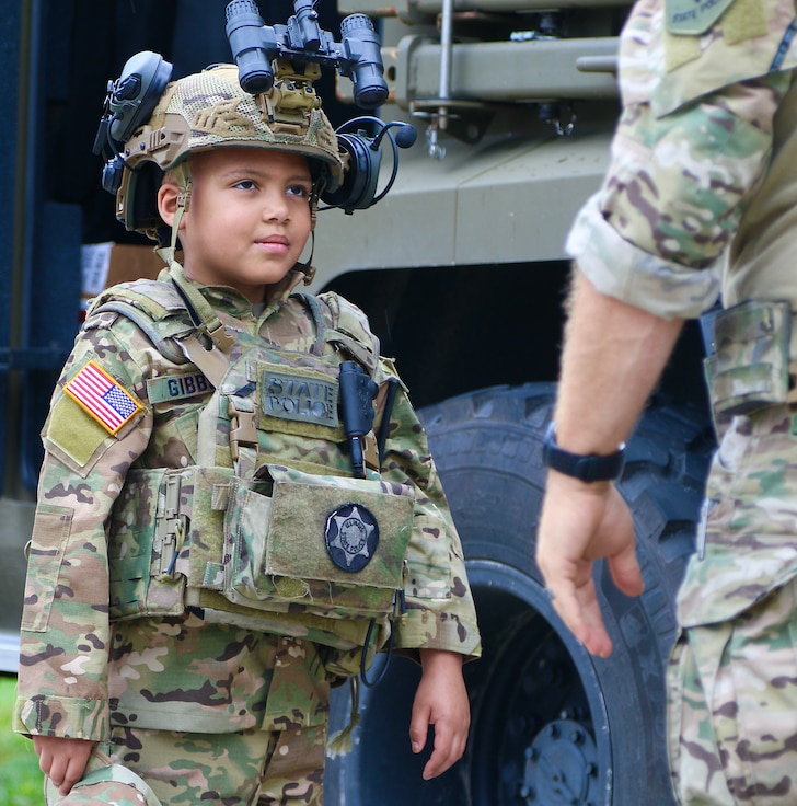 Seven-year-old Jamir Gibbs of Marion, Illinois, listens to an Illinois State Police tactical officer after his "promotion" ceremony. Jamir was promoted to "Honorary First Sergeant" of the Illinois Army National Guard's November Company, Recruit Sustainment Program, Recruiting and Retention Battalion during a ceremony on June 8 at the Illinois Army National Guard's Marion Readiness Center in honor of his courageous fight against cancer.