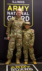 Seven-year-old Jamir Gibbs of Marion, Illinois, poses for a photo with 1st Sgt. Beau Detrick after Jamir's "promotion" ceremony. Jamir was promoted to "Honorary First Sergeant" of the Illinois Army National Guard's November Company, Recruit Sustainment Program, Recruiting and Retention Battalion during a ceremony on June 8 at the Illinois Army National Guard's Marion Readiness Center in honor of his courageous fight against cancer.