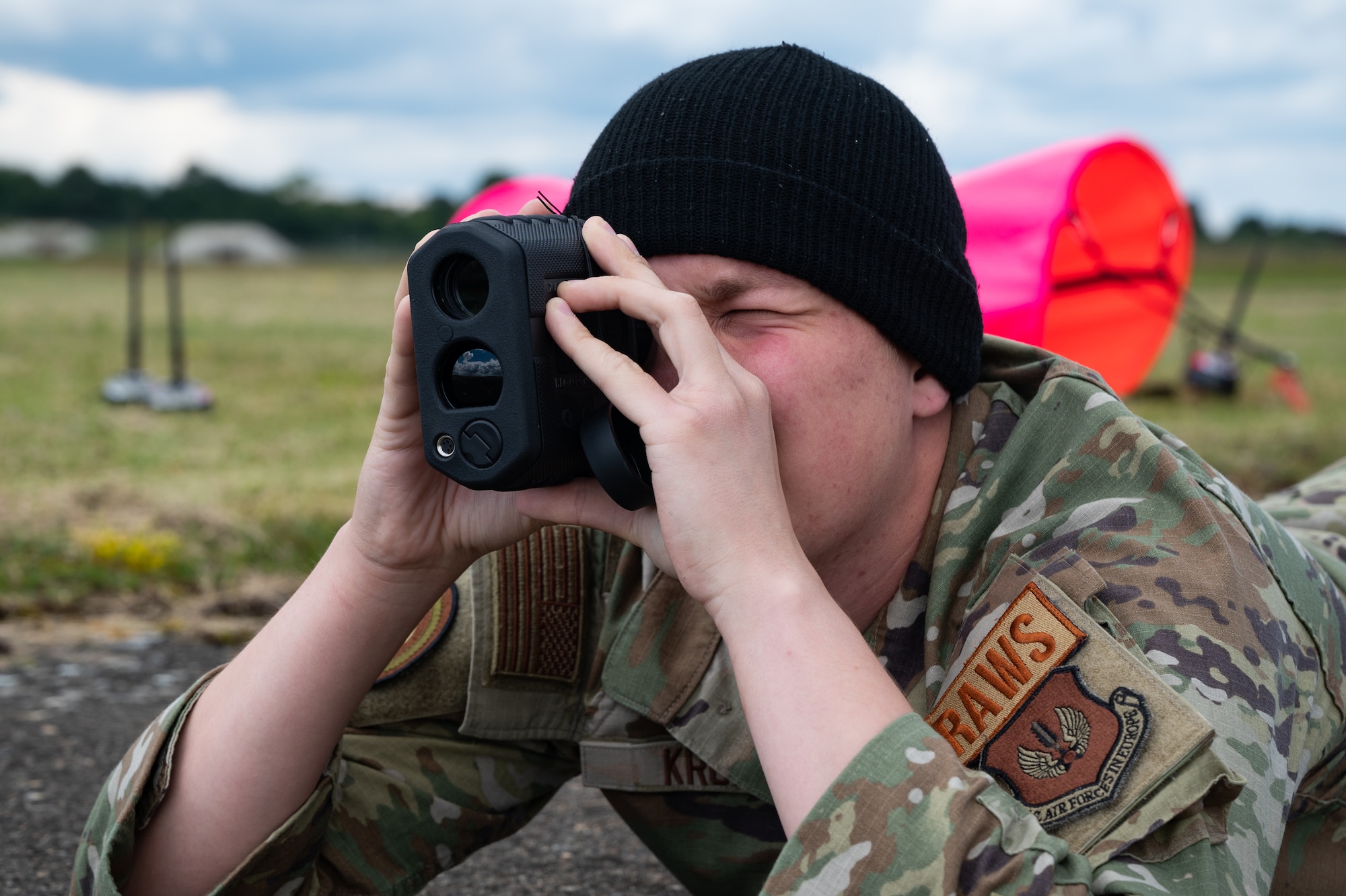 A U.S. Air Force member uses his range finder to determine if the tree line is at a safe distance for a landing zone