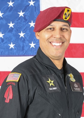 man wearing U.S. Army jump suit stands in front