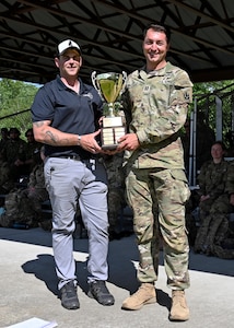 From left, Sgt. 1st Class Joe Wyner, state marksmanship coordinator, New Hampshire Army National Guard, presents Capt. Robert Matzelle, commander of Charlie Company, 3rd Battalion, 172nd Infantry Regiment (Mountain), with the first-place trophy as the 2024 New Hampshire National Guard Combat Marksmanship Match individual champion June 8.