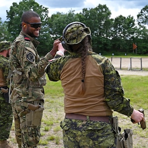 Cabo-Adjunto Ravidson Vezo Lopes of the Cabo Verdean Armed Forces and Master Cpl. Lisa Leopold of the Canadian Armed Forces fist bump after a pitsol match at the 2024 New Hampshire National Guard Combat Marksmanship Match on June 8 at Fort Devens, Mass. About 90 marksmen competed in the event, which featured various pistol and rifle courses of fire. Photo by Master Sgt. Charles Johnston, NHNG Deputy State PAO.